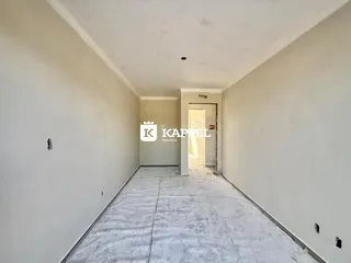 Corredor longo e vazio com paredes brancas e piso claro.