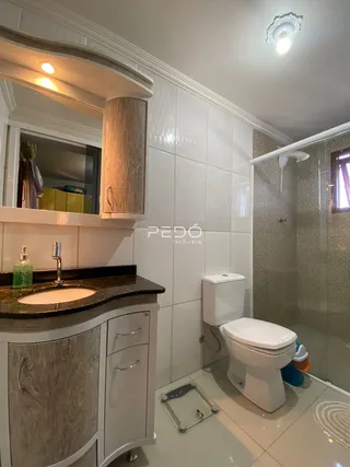 Foto de um banheiro com bancada e box de vidro.