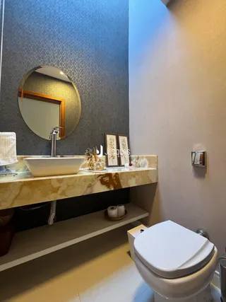 Foto de um banheiro com bancada de mármore e piso claro.