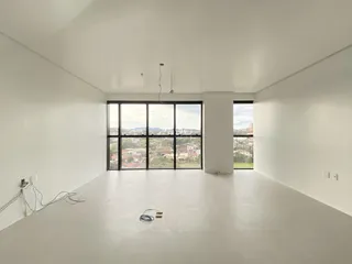 Sala de estar ampla com grandes janelas que oferecem vista para a paisagem.