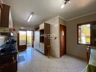 Foto de uma cozinha com armários de madeira e piso cerâmico.
