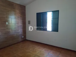 Ambiente interno com piso de cerâmica e parede de madeira.