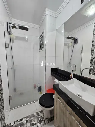 Banheiro com box de vidro e revestimento moderno.