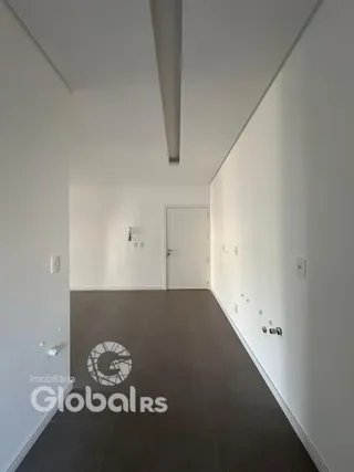 Corredor interno de uma residência com paredes brancas e piso de carpete.