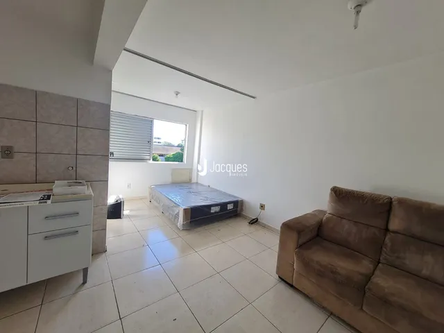 Quarto com cama e sofá em ambiente claro.