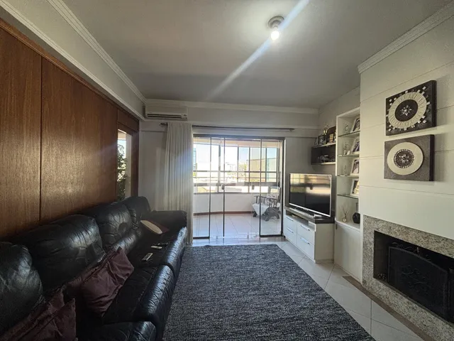Sala de estar com sofá de couro e porta de vidro que dá acesso ao exterior.