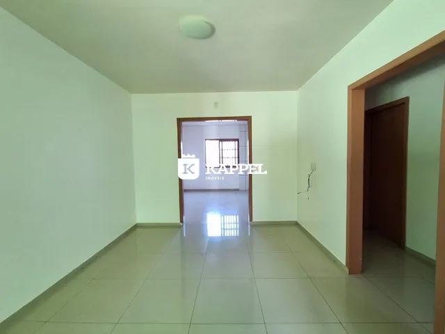 Hall de corredor com piso de cerâmica claro.