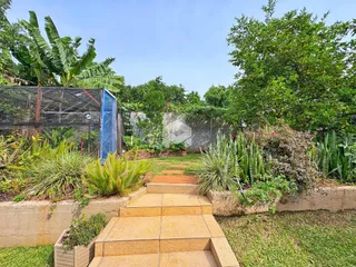Vista do jardim com terraços e vegetação na propriedade.