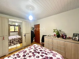 Quarto com armários embutidos e cama decorada em um imóvel em Lajeado.