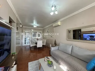 Sala de estar com piso de madeira e área de jantar em imóvel no Brasil.