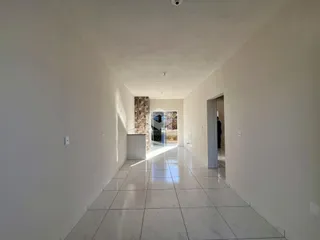 Foto de um corredor interno de uma residência com piso de porcelanato claro.