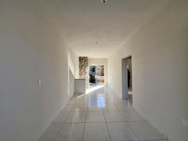 Foto de um corredor interno de uma residência com piso de porcelanato claro.