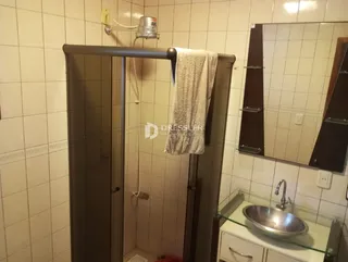 Foto de um banheiro com revestimento cerâmico e espelho.