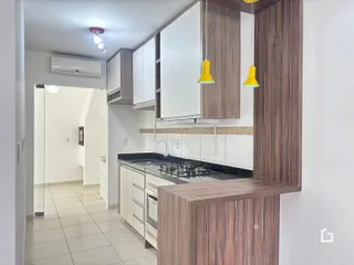 Cozinha moderna com armários brancos e detalhes em madeira.