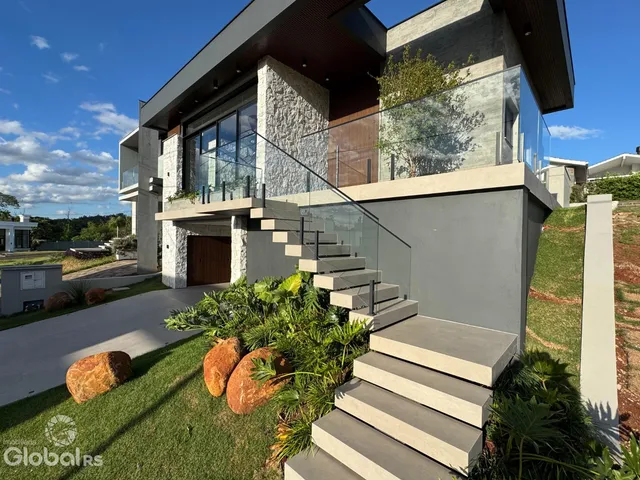 Fachada moderna de uma residência em Lajeado, Brasil, com terraço e jardim.
