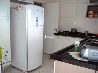 Foto de uma cozinha com geladeira branca e bancada escura.