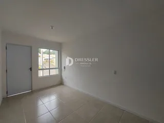 Vista interna de um cômodo com piso de cerâmica e paredes brancas.