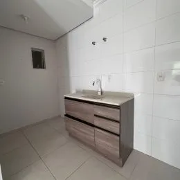 Foto de um banheiro com bancada de madeira e piso claro.