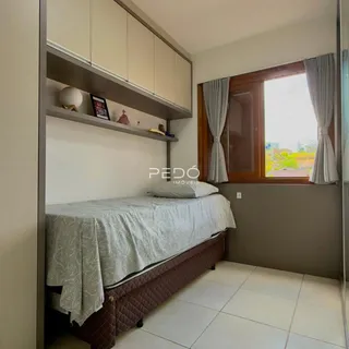 Quarto com cama e estante em um imóvel no Brasil.