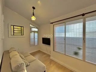 Sala de estar com piso de madeira e portas de vidro grandes.