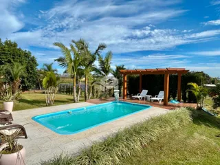Piscina e área externa com vegetação exuberante.