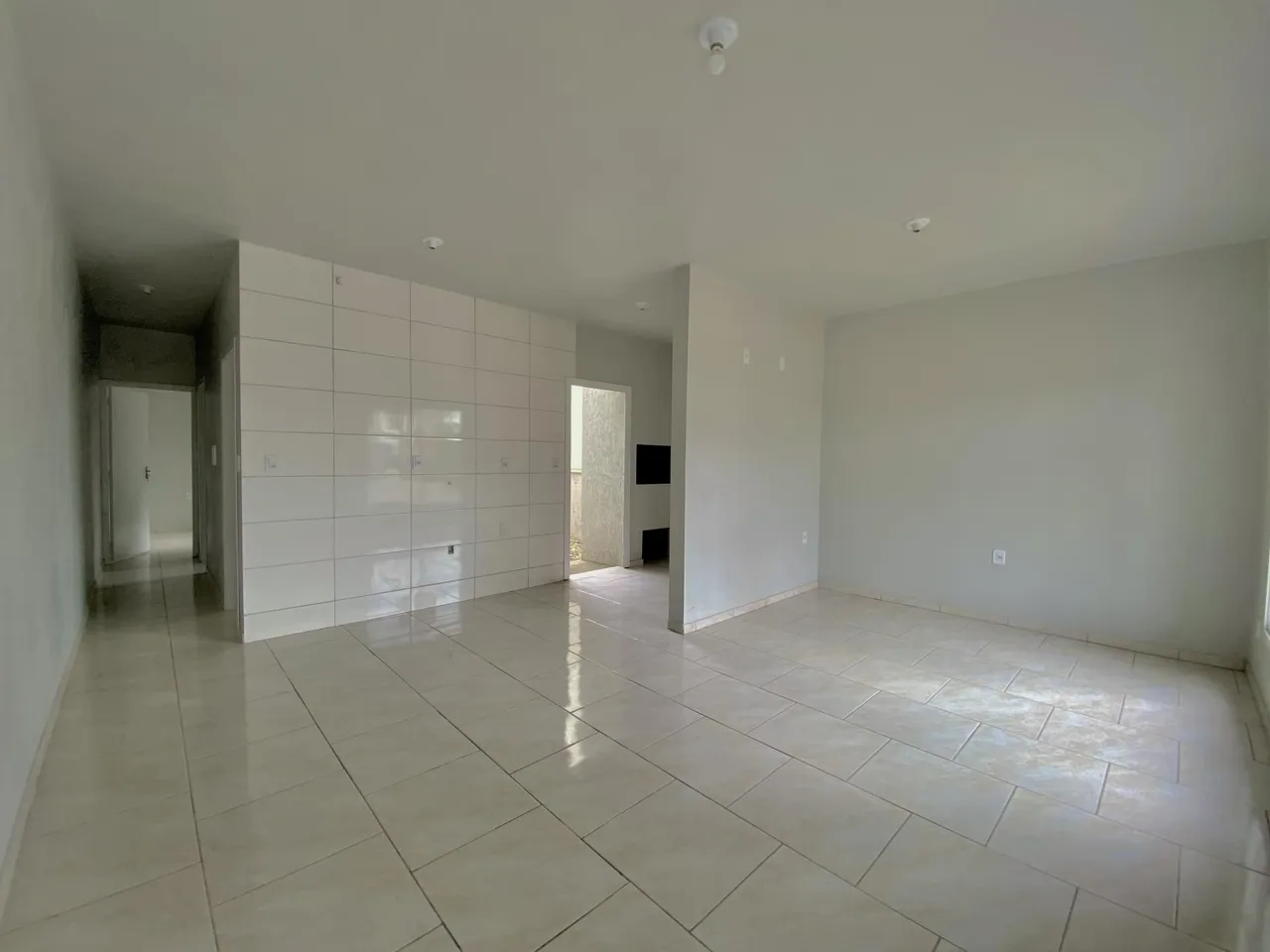 Foto de um ambiente interno com piso de cerâmica e paredes brancas.