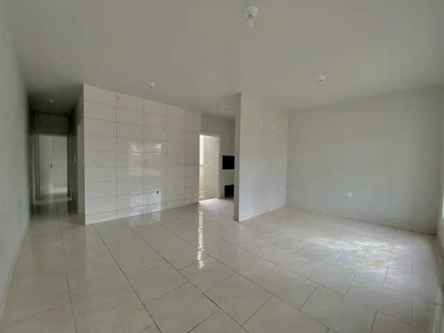 Foto de um ambiente interno com piso de cerâmica e paredes brancas.