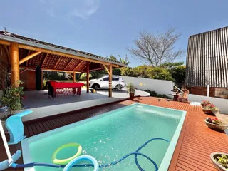 Foto de uma piscina e deck de madeira em uma propriedade.