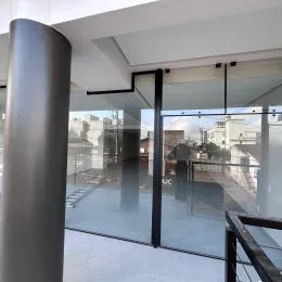 Hall de entrada com portas de vidro e piso polido.
