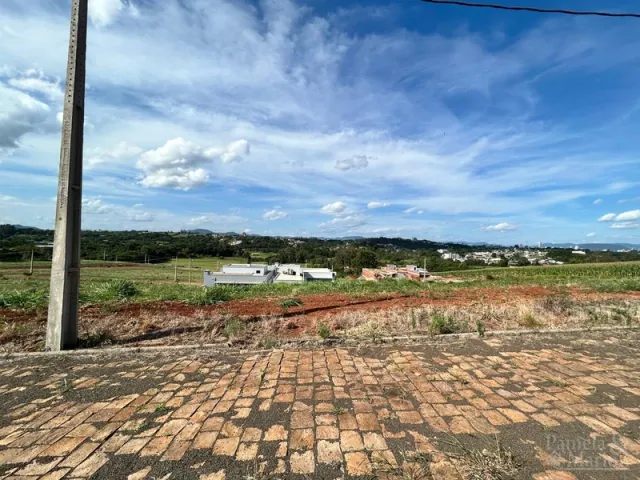 Vista externa de um terreno com paisagem de campo e céu azul no horizonte.