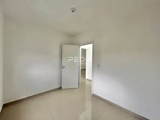 Interior de um corredor com piso de cerâmica claro.