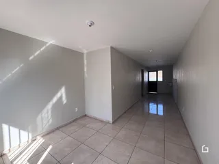 Corredor interno de uma residência com piso de cerâmica.