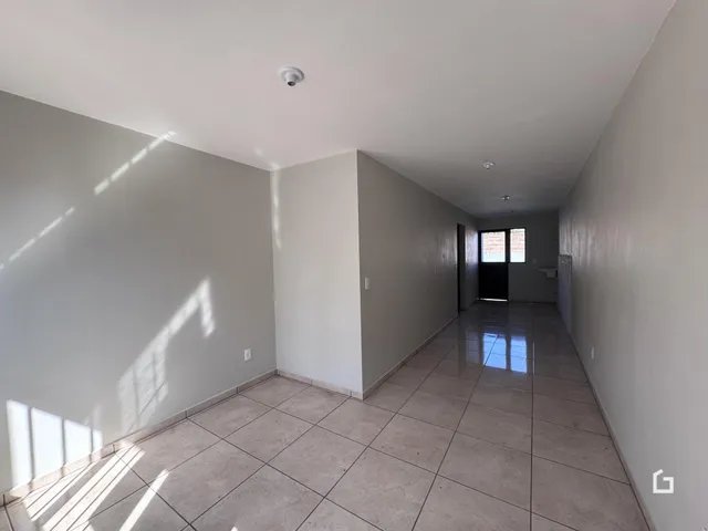 Corredor interno de uma residência com piso de cerâmica.