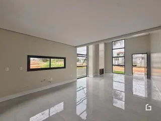 Sala ampla com piso reflexivo e portas de vidro que dão acesso ao exterior.