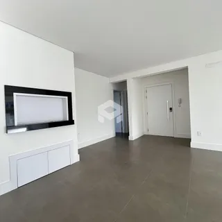 Ambiente interno de uma sala com paredes brancas e piso cinza.