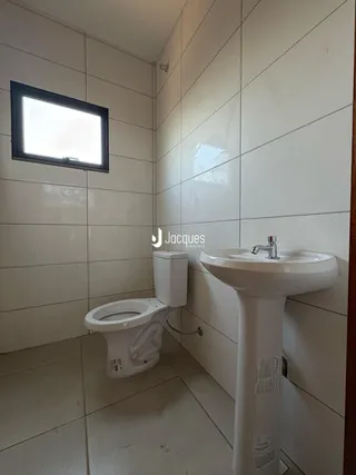Foto interna de um banheiro com revestimento cerâmico branco.