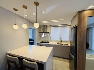 Vista da cozinha moderna com armários e iluminação em um imóvel no Brasil.