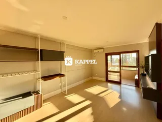 Uma sala de estar com prateleiras de madeira e porta de vidro.