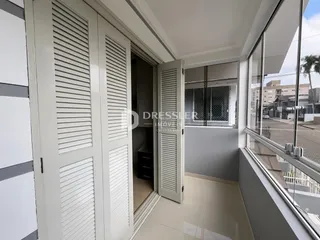 Vista interna de uma área com portas brancas e grande janela.