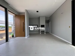 Ambiente interno com piso claro e paredes cinzas em um espaço aberto.