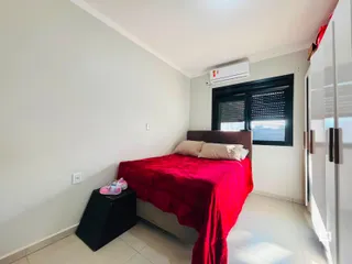 A foto mostra um quarto com cama e janela em uma residência.