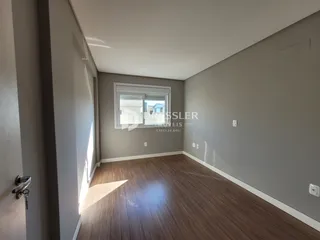 Uma sala de estar com piso de madeira e paredes cinzas.