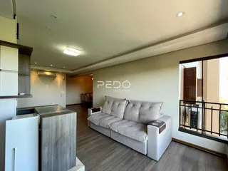 Sala de estar com sofá e piso de madeira em um imóvel no Brasil.