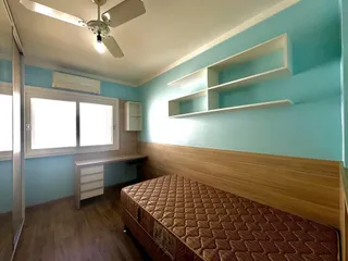 Quarto com cabeceira de madeira e janela no ambiente