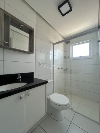Banheiro moderno com piso de cerâmica e box de vidro.