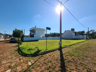 Fachada de uma casa branca com gramado verde em um dia ensolarado.