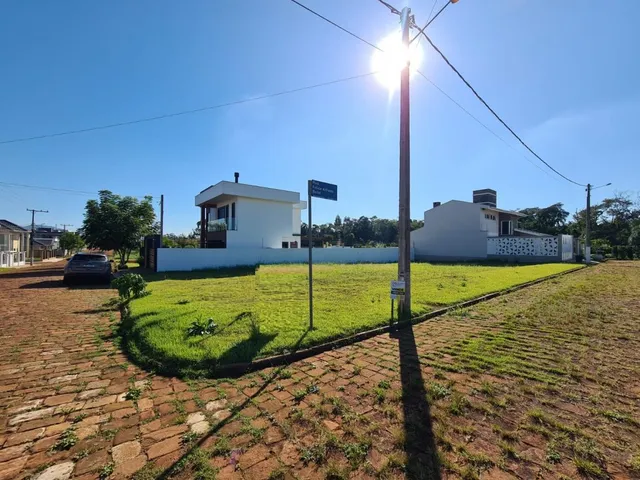 Fachada de uma casa branca com gramado verde em um dia ensolarado.
