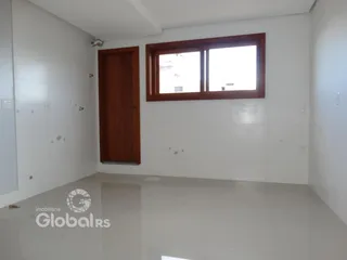 Ambiente interno de uma sala com paredes brancas e porta de madeira.