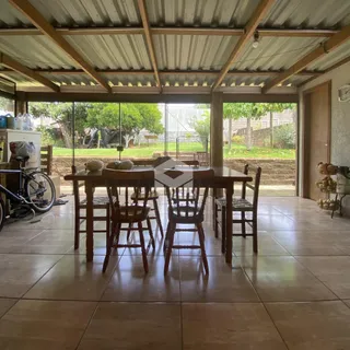 Uma área de jantar coberta com vista para o jardim externo.