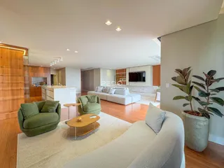 Sala de estar de um apartamento com piso de madeira e decoração moderna.